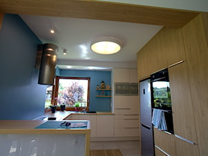 Dom jednorodzinny z akcentami morskimi - Średnia otwarta z salonem niebieska z zabudowaną lodówką z nablatowym zlewozmywakiem kuchnia w kształcie litery g z oknem, styl nowoczesny - zdjęcie od Archideko