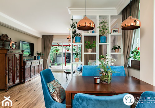 Współczesna jadalnia z niebieskimi klasycznymi krzesłami i miedzianymi lampami - zdjęcie od One Studio