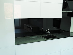 Kuchnia biała z czarnym blatem kompaktowym - Średnia otwarta z kamiennym blatem czarna z zabudowaną lodówką z nablatowym zlewozmywakiem kuchnia w kształcie litery l z oknem, styl minimalistyczny - zdjęcie od ELIT MEBLE