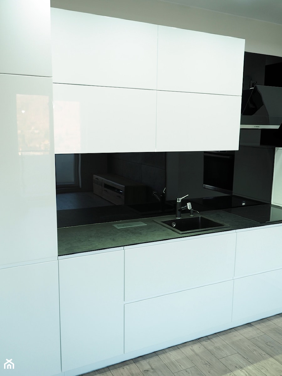 Kuchnia biała z czarnym blatem kompaktowym - Średnia otwarta z kamiennym blatem czarna z zabudowaną lodówką z nablatowym zlewozmywakiem kuchnia w kształcie litery l z oknem, styl minimalistyczny - zdjęcie od ELIT MEBLE