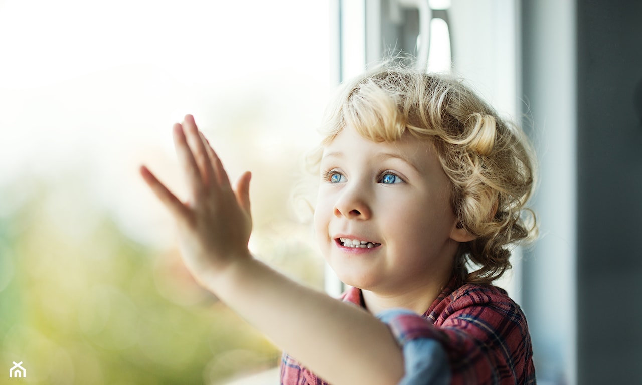 chłopiec dotykający szyby, chłopiec przy oknie