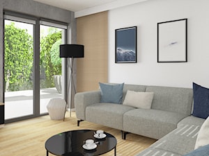 Mały salon z dużą sofą. Połączenie betonu z drewnianą podłogą i ozdobnymi listwami ściennymi. - zdjęcie od Boka Design