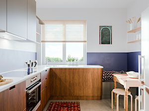 Mieszkanie w krakowskiej Nowej Hucie - Mała zamknięta z kamiennym blatem biała niebieska z zabudowaną lodówką z nablatowym zlewozmywakiem kuchnia w kształcie litery l z oknem, styl nowoczesny - zdjęcie od one desk