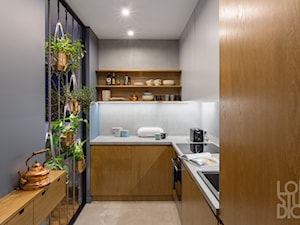 Apartament na Dworskiej - Mała zamknięta z kamiennym blatem szara z zabudowaną lodówką z lodówką wolnostojącą z nablatowym zlewozmywakiem kuchnia w kształcie litery l, styl nowoczesny - zdjęcie od Loftstudio