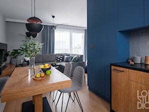 Mieszkanie z niebieskim motywem - Średnia niebieska szara jadalnia w salonie w kuchni, styl nowoczesny - zdjęcie od Loftstudio