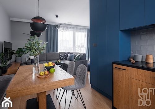 Mieszkanie z niebieskim motywem - Średnia niebieska szara jadalnia w salonie w kuchni, styl nowocz ... - zdjęcie od Loftstudio