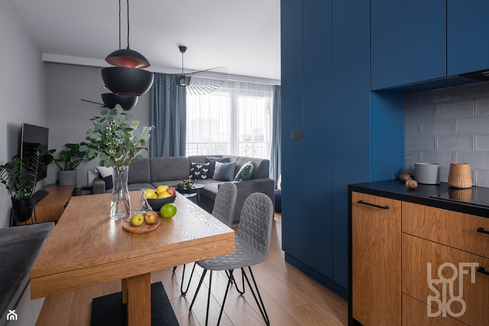 Mieszkanie z niebieskim motywem - Średnia niebieska szara jadalnia w salonie w kuchni, styl nowocz ... - zdjęcie od Loftstudio - Homebook