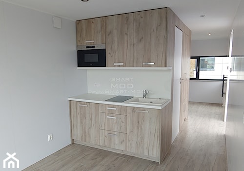 Dom z dostawą na działkę - Apartament 25 - Mała otwarta z kamiennym blatem biała z zabudowaną lodówką z nablatowym zlewozmywakiem kuchnia jednorzędowa, styl minimalistyczny - zdjęcie od Smart Mod