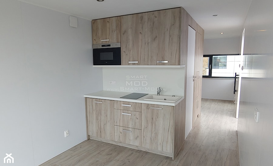 Dom z dostawą na działkę - Apartament 25 - Mała otwarta z kamiennym blatem biała z zabudowaną lodówką z nablatowym zlewozmywakiem kuchnia jednorzędowa, styl minimalistyczny - zdjęcie od Smart Mod
