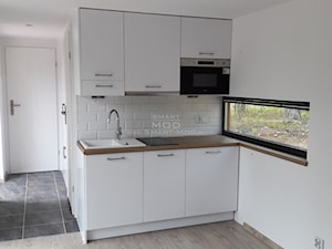 Dom z dostawą na działkę - Apartament 35 - Mała otwarta biała z zabudowaną lodówką z nablatowym zlewozmywakiem kuchnia w kształcie litery l z oknem, styl minimalistyczny - zdjęcie od Smart Mod