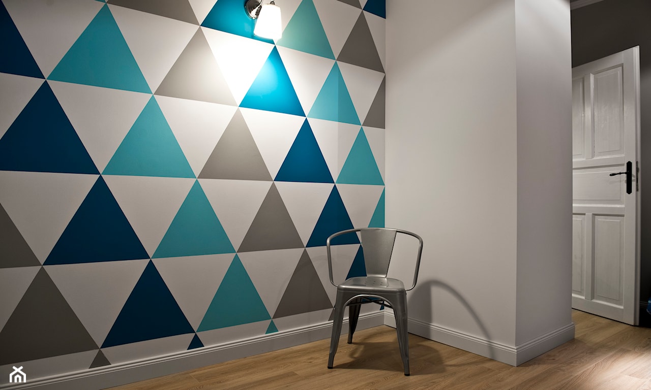 metalowe krzesło, tapeta w trójkąty w odcieniach niebieskiego, podłoga z jasnego drewna