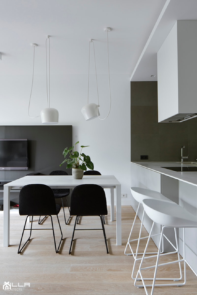 Apartament na Żoliborzu / 100m2 - Duża biała czarna jadalnia w salonie - zdjęcie od TILLA architects