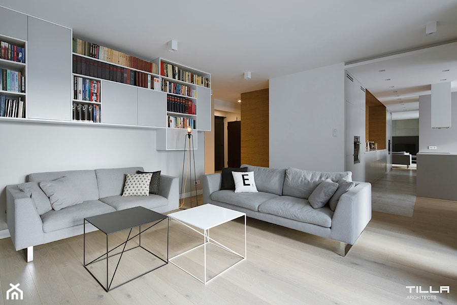 Realizacja w Warszawie/ 90 m2 - Duży szary salon z bibiloteczką, styl minimalistyczny - zdjęcie od TILLA architects