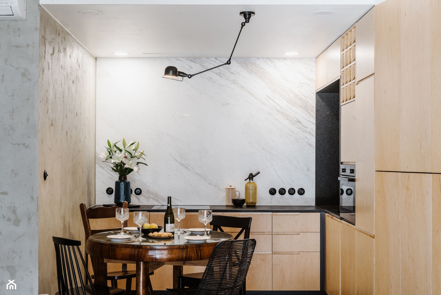 Mieszkanie na Mokotowie - Mała otwarta z salonem biała czarna z zabudowaną lodówką kuchnia w kształcie litery l z kompozytem na ścianie nad blatem kuchennym z marmurem nad blatem kuchennym - zdjęcie od Mili Młodzi Ludzie - Homebook