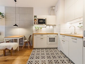 Apartament w Wilanowie - Średnia otwarta z salonem biała szara z zabudowaną lodówką z nablatowym zlewozmywakiem kuchnia w kształcie litery l, styl skandynawski - zdjęcie od Fotownętrza