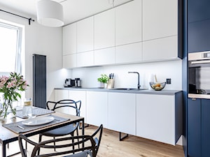 Mieszkanie z kostką Poznań - Średnia otwarta z kamiennym blatem biała z zabudowaną lodówką z lodówką wolnostojącą z nablatowym zlewozmywakiem kuchnia jednorzędowa z oknem, styl minimalistyczny - zdjęcie od zonaarchitekci