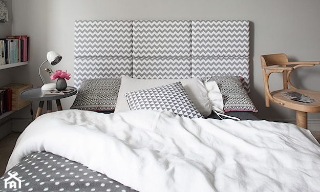 szara ściana, łóżko z zagłówkiem w zygzaki, poduszka w zygzaki, pościel w białe kropki