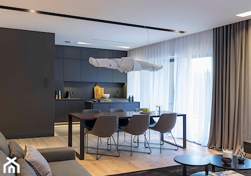 Apartament z czarną kuchnią. - Średni czarny szary salon z kuchnią z jadalnią, styl minimalistyczny - zdjęcie od Banach Architekci
