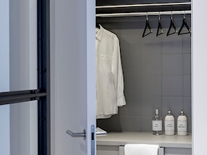 Apartament z czarną kuchnią. - Garderoba, styl minimalistyczny - zdjęcie od Banach Architekci
