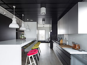 Mieszkanie w czerni - Duża otwarta z kamiennym blatem biała czarna z zabudowaną lodówką z nablatowym zlewozmywakiem kuchnia dwurzędowa z oknem - zdjęcie od DNAarchitekci
