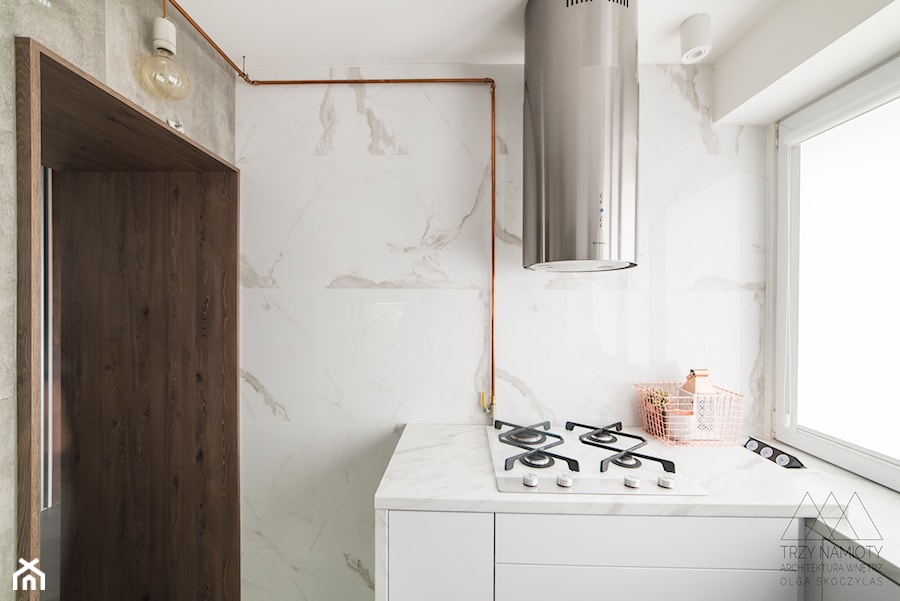 Mieszkanie w wielkiej płycie - Mała zamknięta biała z zabudowaną lodówką kuchnia jednorzędowa z oknem z marmurem nad blatem kuchennym, styl minimalistyczny - zdjęcie od Trzy Namioty