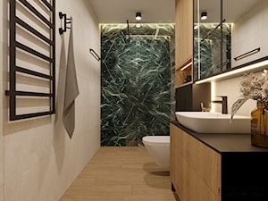 Drewnopodobne fronty szafek, czarny blat kamienny, czarna armatura w łazience, piękne zielone płytki pod prysznicem, szafka z lustrem - zdjęcie od Monika Hardej Architekt