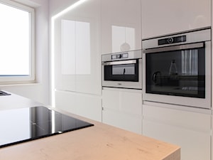 energia bieli - Średnia otwarta z salonem biała z zabudowaną lodówką z nablatowym zlewozmywakiem kuchnia dwurzędowa z oknem, styl industrialny - zdjęcie od totalwhitephoto