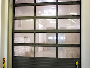 Przemysłowa brama segmentowa z przeszkleniem Wiśniowski - zdjęcie od OLBUD OGRODZENIA BRAMY DRZWI I OKNA STRASZYN