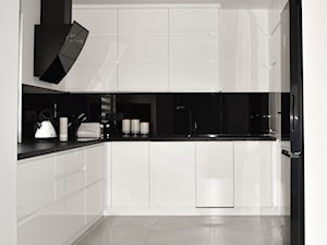 Kuchnia w bieli i czerni - Średnia otwarta z salonem biała czarna z zabudowaną lodówką z lodówką wolnostojącą z podblatowym zlewozmywakiem kuchnia w kształcie litery u, styl minimalistyczny - zdjęcie od Design Concept Studio Architektura Wnętrz