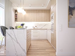 Elegancka kuchnia z białymi i drewnianymi frontami oraz złotymi uchwytami - zdjęcie od VISO Pracownia Projektowa