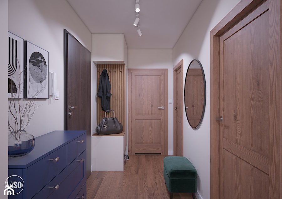 Przedpokój w stonowanych kolorach, drewniane drzwi oraz podłoga, granatowa szafka, szafa z siedziskiem - zdjęcie od VISO Pracownia Projektowa
