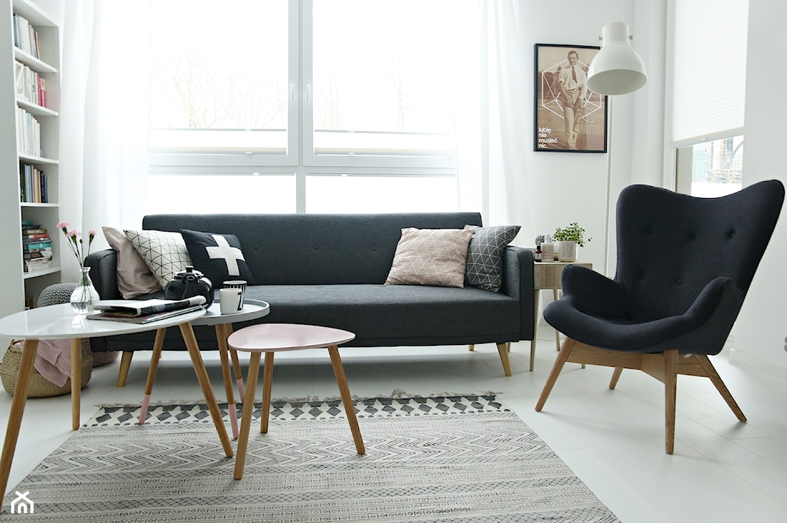 salon w stylu skandynawskim z czarną sofą i ciemnym fotelem
