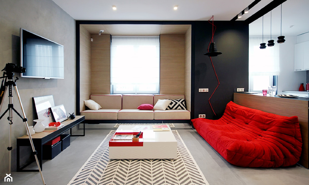 nowoczesny salon, czerwona sofa, czarna ściana, betonowa ściana, industrialna lampa na czerwonym kablu