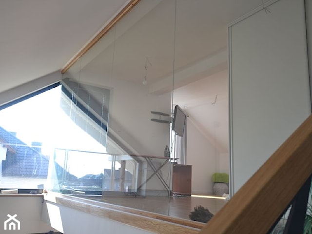 Nowoczesne schody dywanowe z ażurową ścianą i szklaną balustradą