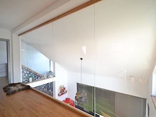 Nowoczesne schody dywanowe z ażurową ścianą i szklaną balustradą