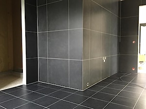 Czarna łazienka z kamieniami rzecznymi w strefie prysznicowej
