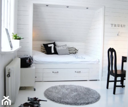 łóżko we wnęce, szary dywanik, białe panele na ścianach, czarne krzesło