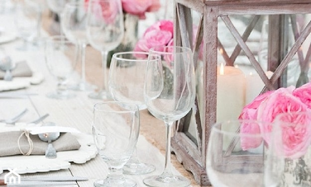 szklane kieliszki, różowe kwiaty, metalowy lampion, biała świeczka