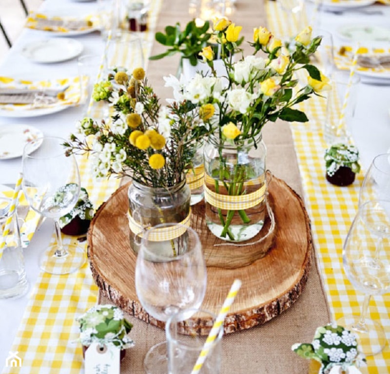 letni stół w ogrodzie, kwiaty polne w słoikach, żółty bieżnik w kratkę