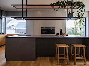 Dom z klimatem - Duża otwarta z zabudowaną lodówką kuchnia z wyspą lub półwyspem z oknem, styl nowoczesny - zdjęcie od TK Architekci