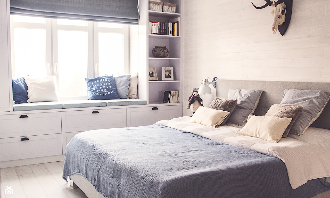 sypialnia w stylu skandynawskim, niebieska narzuta, białe meble