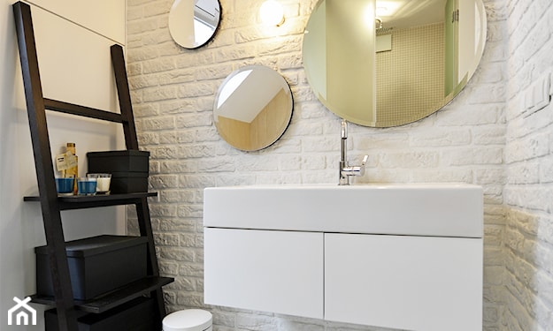łazienka z białą cegła i okrągłymi lustrami