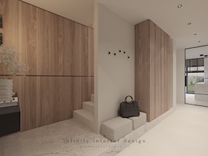 Przedpokój z dużą szafą i siedziskiem - zdjęcie od Infinity Interior Design