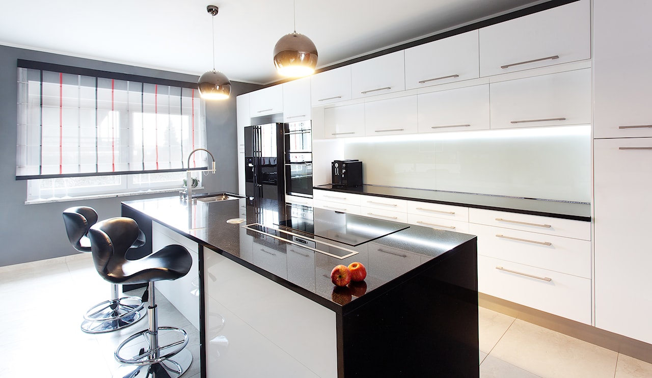 minimalistyczna kuchnia, granitowe blaty kuchenne, białe szafki kuchenne, srebrny klosz lampy