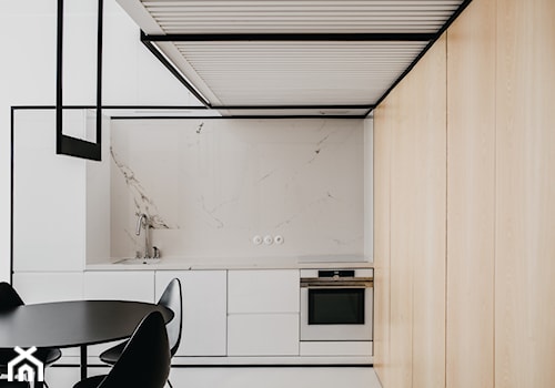 Apartament w Krakowie - Średnia otwarta biała z zabudowaną lodówką z podblatowym zlewozmywakiem kuchnia w kształcie litery l z marmurem nad blatem kuchennym, styl minimalistyczny - zdjęcie od MUS ARCHITECTS