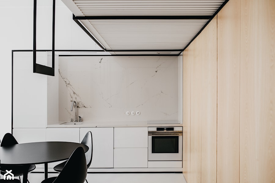 Apartament w Krakowie - Średnia otwarta biała z zabudowaną lodówką z podblatowym zlewozmywakiem kuchnia w kształcie litery l z marmurem nad blatem kuchennym, styl minimalistyczny - zdjęcie od MUS ARCHITECTS