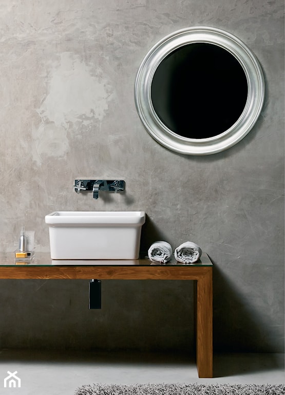 łazienka w stylu industrialnym, betonowa ściana, umywalka nablatowa, okrągłe lustro ze srebrną ramą