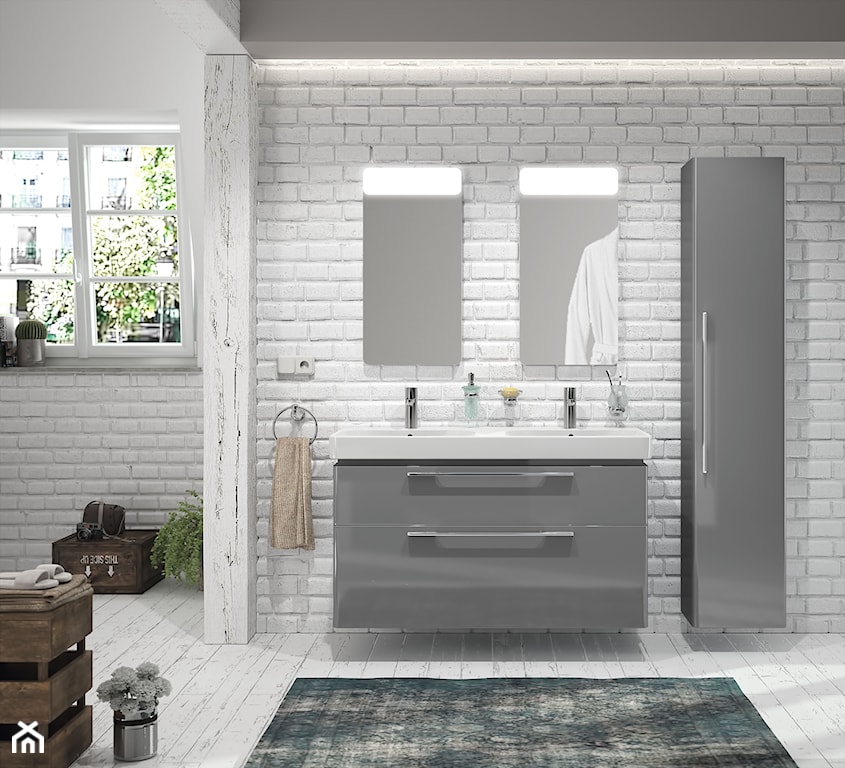 ściana z białej cegły w łazience, szare szafki łazienkowe z połyskiem, lustro ścienne łazienkowe z lampą
