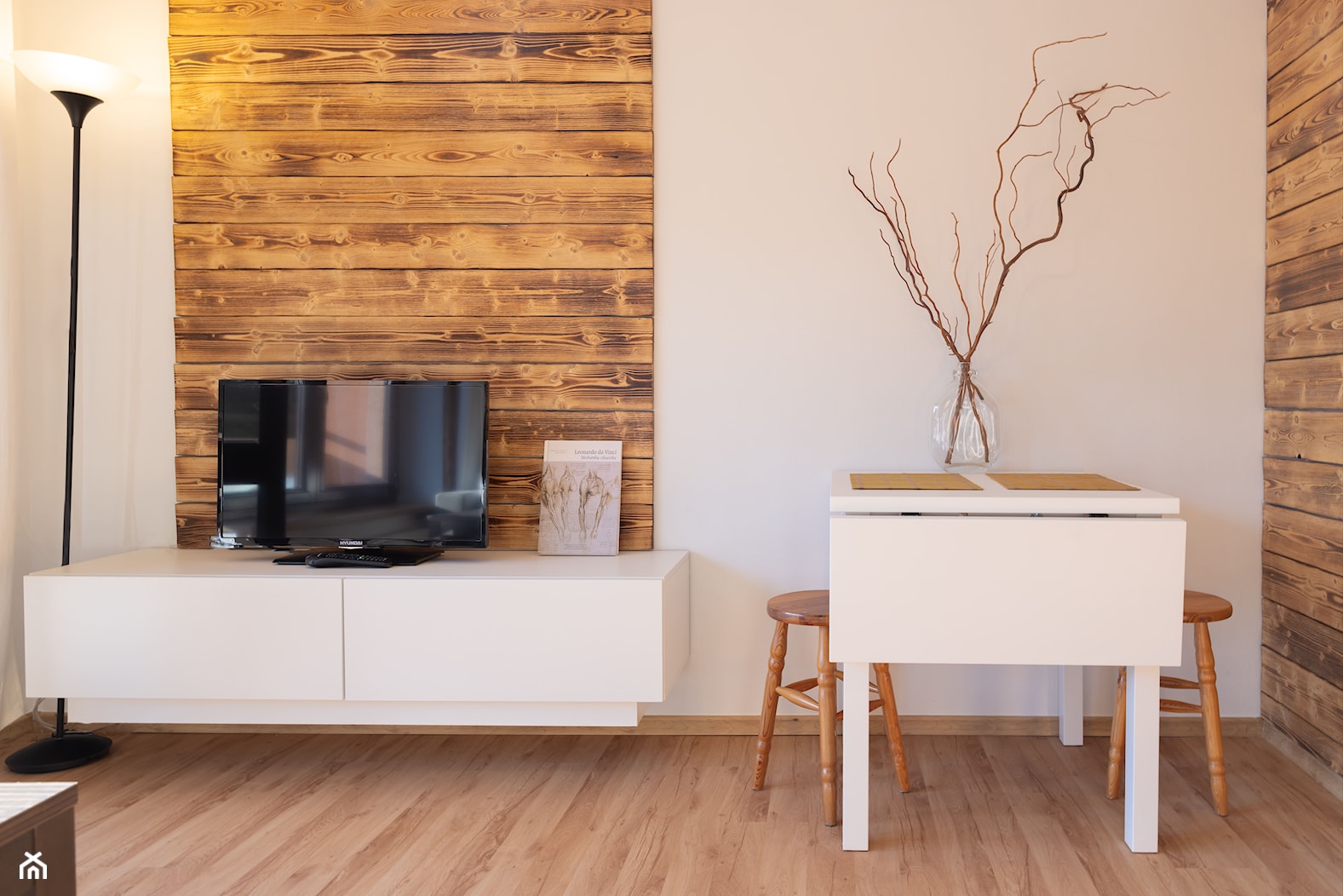 Salon z jadalnią - mały, biały, drewniane dodatki, deska opalana, drewno, dwa łóżka - zdjęcie od M8 Studio - Paula Tylek - Homebook
