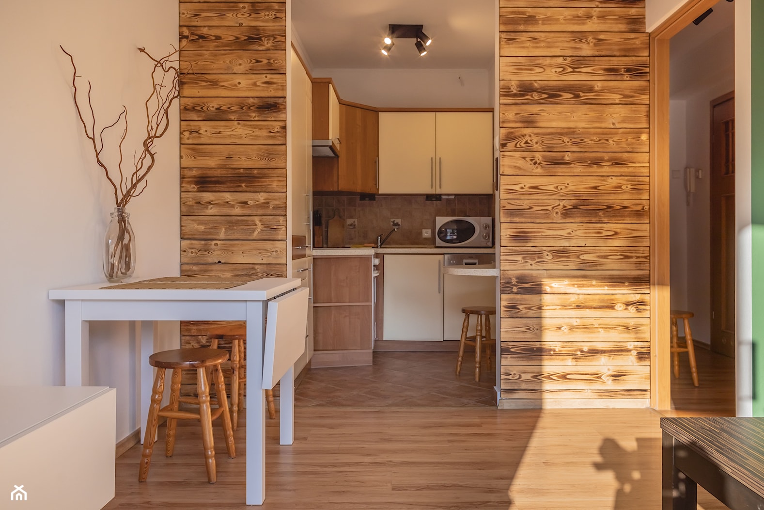 Salon z widokiem na kuchnię - mały, zielona, drewniane dodatki, deska opalana, drewno, dwa łóżka - zdjęcie od M8 Studio - Paula Tylek - Homebook